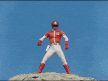 a man in a red and white superhero costume stands in front of a red explosion