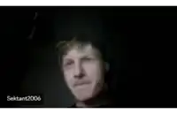 a blurry picture of a man making a funny face with his tongue out