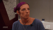 a woman with purple hair and a blue shirt is on a pop tv show