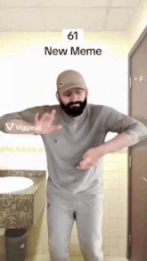 a man with a beard is dancing in a bathroom with the number 61 on the bottom