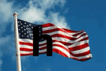 an american flag is waving in the wind against a blue sky with clouds .