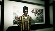 a man wearing sunglasses and a dreadlock stands in front of a picture