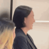 a woman with short black hair is sitting next to a woman with blonde hair .