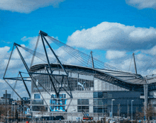 a stadium with a blue sky and clouds behind it