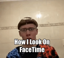 a young man wearing glasses and a wig is standing in front of a bathroom mirror .