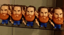 a row of bearded figurines are lined up on a shelf