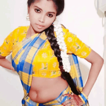 a woman wearing a yellow and blue plaid blouse and a blue and yellow saree