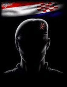 a silhouette of a man wearing a beret with a flag in the background .