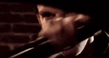 a man is holding a flashlight in his hand in front of his face .