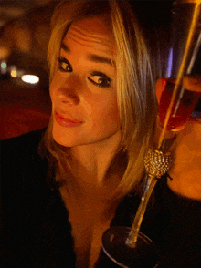 a woman is holding a glass with a rhinestone ring on it