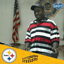 a man in a striped shirt with the pittsburgh steelers logo in the corner