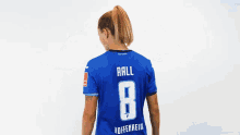 a woman wearing a blue jersey with the number 8 on the back