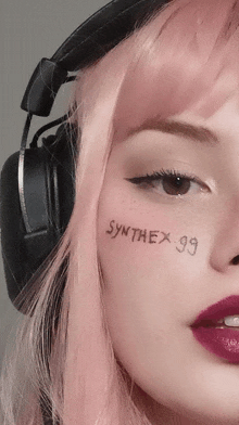 a close up of a woman 's face with synthex 99 written on it