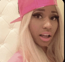 a blonde woman wearing a pink hat and pink lipstick