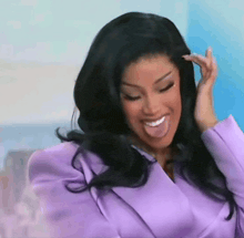 a woman wearing a purple suit is sticking her tongue out