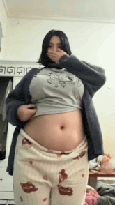 a woman covering her mouth with her hand while wearing a shirt that says ' snoopy ' on it