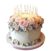 a white cake with pink roses and candles and the letters a.c. on it