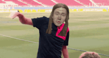 a man with long hair is standing on a soccer field with a jesus face on his shirt