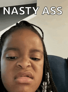 a little girl is making a funny face with the words nasty ass behind her