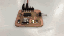 a small circuit board with a button and a few wires connected to it