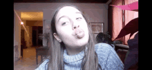a girl wearing a turtleneck sweater is making a funny face