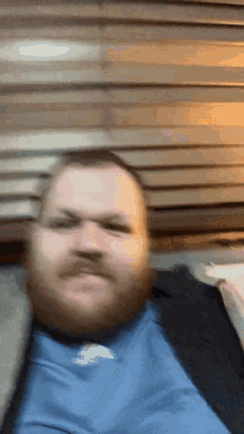 a man with a beard is wearing a blue shirt with adidas on it