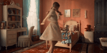 a girl in a white dress is dancing in a room