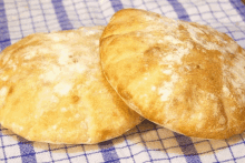 two pieces of bread are sitting on a blue and white checkered towel