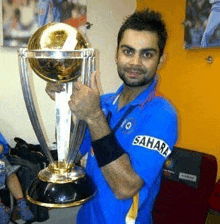 a man is holding a trophy in his hands .