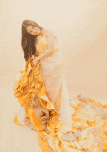 a woman wearing a yellow and white dress with ruffles on the skirt