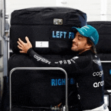 a man is hugging a large black bag that says left on it