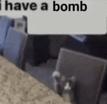 a cat is sitting on a couch in a room with a sign that says `` i have a bomb '' above it .