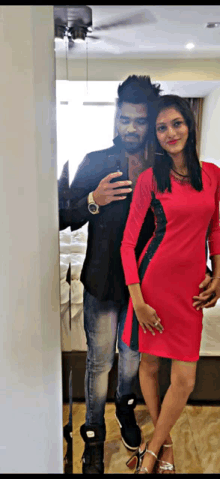 a man and a woman taking a picture in front of a mirror