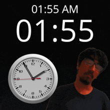 a man stands in front of a clock that says 01:55