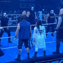 a group of wrestlers are standing in a ring and one of them is wearing a shirt that says mcw