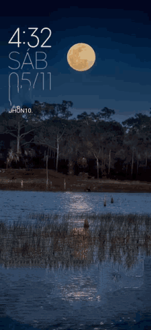 a full moon rises over a body of water with the time of 4:32