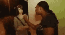 a man and a woman are standing next to each other in front of a painting .