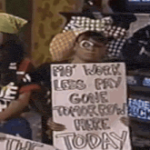 a man holding a sign that says " my work less pay gone tomorrow here today "