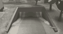 a black and white drawing of a tunnel with trees behind it