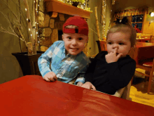 a boy in a red hat sits next to a girl