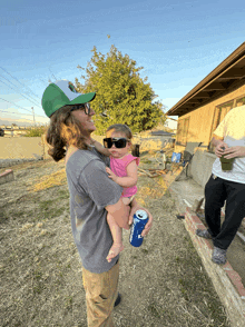 a man is holding a baby and a can of bud light