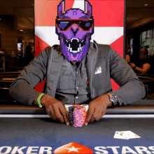 a man playing poker with a purple monster on his face