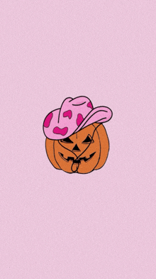 a pumpkin wearing a pink cow print cowboy hat