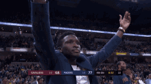 a man stands in front of a crowd with his arms in the air during a basketball game between cavaliers and pacers