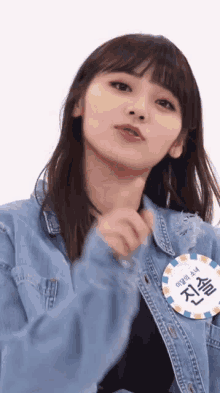 a girl wearing a denim jacket and a name tag with chinese writing