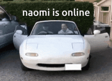 a white car is parked in front of a hedge with the words naomi is online above it