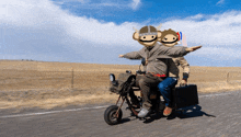 a man riding a motorcycle with two monkeys on the back