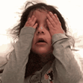 a little girl wearing a shirt that says i 'm rolling covers her eyes with her hands