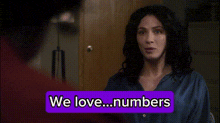 a woman is standing in front of a door with a purple sign that says we love numbers .