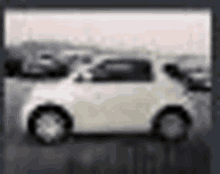 a white car is parked in a parking lot in a blurry picture .